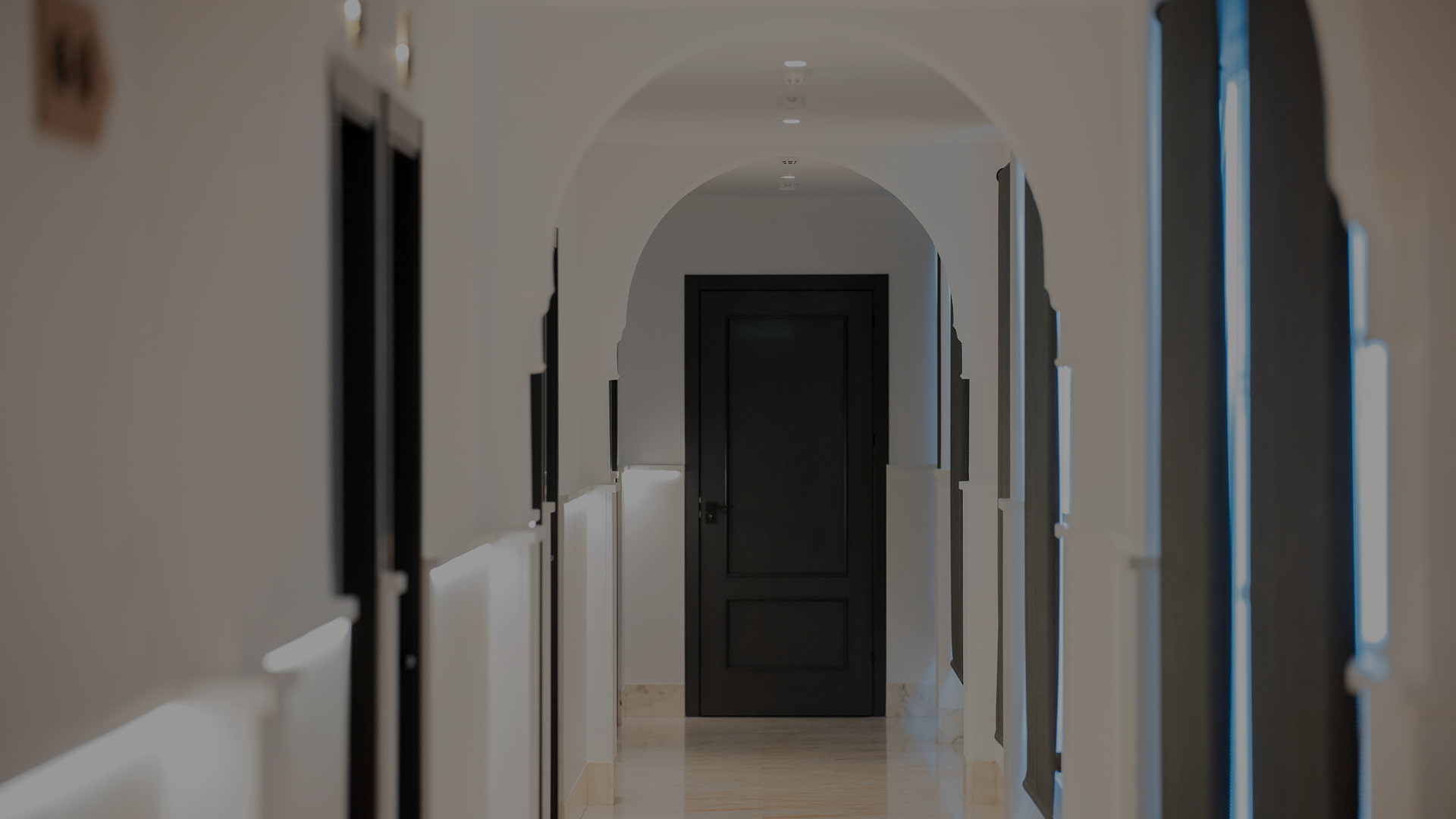 Nuestras Habitaciones Hermoso pasillo con arcadas que conduce a las habitaciones del hotel