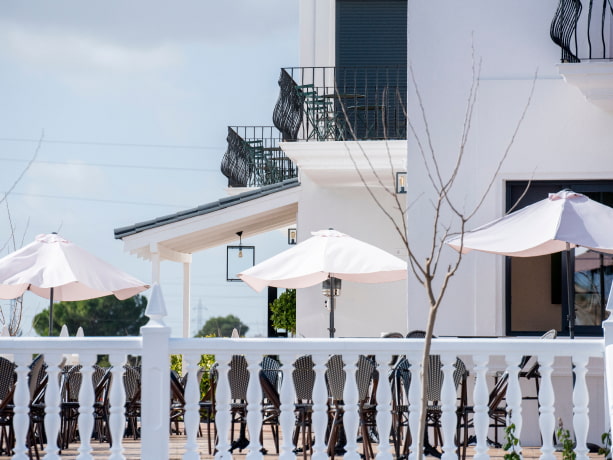 Terraza equipa con mesas, sillas y elegantes sombrillas