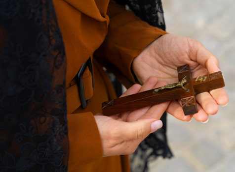 Semana Santa Mujer sosteniendo un crucifijo de madera