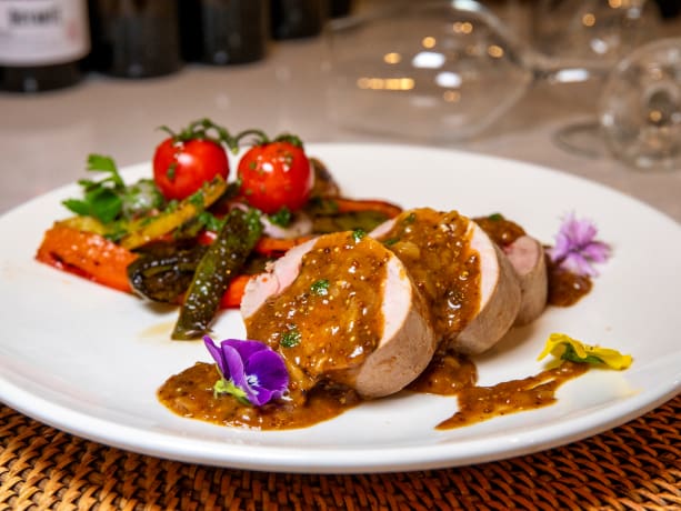 Plato de carne con un emplatado espectacular, acompañado de verduras asadas